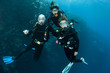 three friends scuba diving together