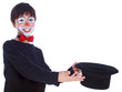 smiling child performing magic hat tricks isolated on white