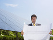 businessman standing near solar panels