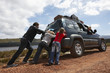 Father and kids pushing a car