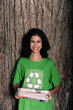 woman with recycling sign on shirt holding newspapers