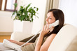 On the phone home: Young woman calling in lounge On the phone home: Young woman calling in lounge