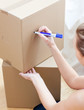 Delighted woman writing on a box
