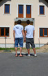 Same-sex couple standing in front of their new house