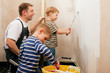 Vater malert Wand mit Söhnen Vater malert Wand mit Söhnen