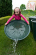 Mädchen spielt mit Wasser im Garten