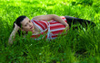 pregnant woman lies on green grass