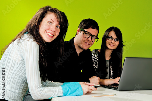 Photo: Two attractive girls and a guy working in office Two attractive girls and a guy working in office