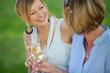 lachenende frauen trinken weißwein