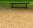 Empty Bench Between Sawdust and Grass