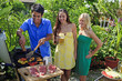 three friends having a barbecue lunch in their tropical garden