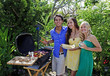 three friends having a barbecue lunch in their tropical garden three friends having a barbecue lunch in their tropical garden