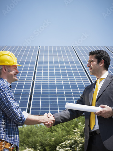 Photo: businessman and electrician shaking hands businessman and electrician shaking hands