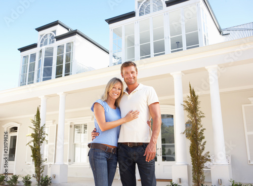 Foto: Young Couple Standing Outside Dream Home Young Couple Standing Outside Dream Home