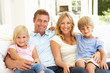 Portrait Of Young Family Relaxing Together On Sofa