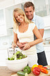 Couple Preparing Salad In Modern Kitchen