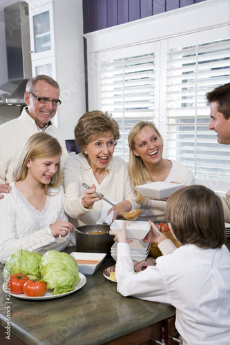 Photo: Three generation family in kitchen eating lunch Three generation family in kitchen eating lunch