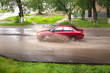 The red car goes on city road to a strong bad weather The red car goes on city road to a strong bad weather