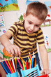 Child  with pencil in play room.