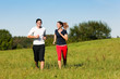 Sport-Paar joggt auf Wiese im Sommer