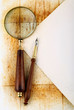 pen and magnifier  on old textured paper