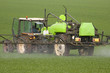 Tracteur pulvérisant du désherbant sur un champ de blé Tracteur pulvérisant du désherbant sur un champ de blé