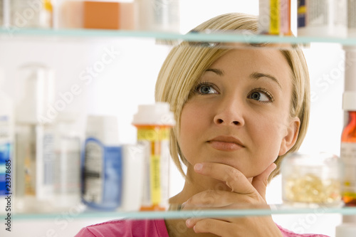 Photo: Woman Looking in Medicine Cabinet Woman Looking in Medicine Cabinet