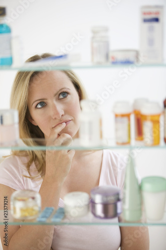 Photo: Woman Looking in Medicine Cabinet Woman Looking in Medicine Cabinet