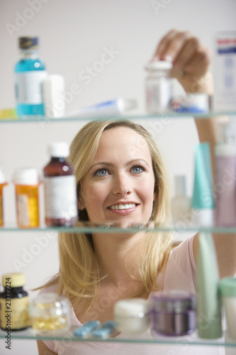 Foto: Woman Looking in Medicine Cabinet Woman Looking in Medicine Cabinet