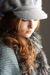 Fashionable Teenage Girl Wearing Cap And Knitwear In Studio
