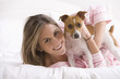 Young Woman Playing With Her Dog on the Bed