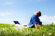 Photo: \Man working with laptop in a meadow of flowers with copyspace \Man working with laptop in a meadow of flowers with copyspace