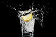 splash in a glass with lemon and ice on a black background