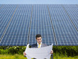 businessman standing near solar panels
