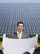 businessman standing near solar panels