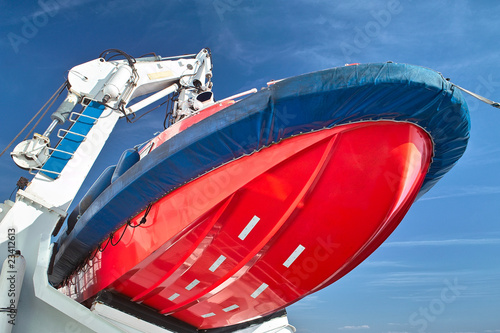 Emergency boat. Red lifeboat hung on the davit Emergency boat. Red lifeboat hung on the davit