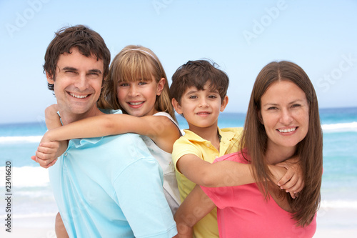 Photo: Family Having Piggyback Fun On Beach Holiday Family Having Piggyback Fun On Beach Holiday