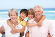 Photo: Grandparents And Grandchildren Relaxing On Beach Holiday Grandparents And Grandchildren Relaxing On Beach Holiday