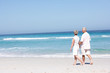 Photo: Senior Couple On Holiday Running Along Sandy Beach Senior Couple On Holiday Running Along Sandy Beach