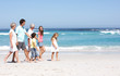 Three Generation Family Walking Along Sandy Beach