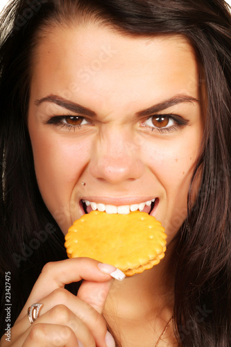 Photo: Woman eating cookie with anger Woman eating cookie with anger