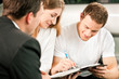Couple signing sales contract at car dealer