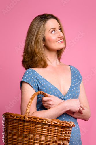Photo: Woman carrying wicker shopping basket Woman carrying wicker shopping basket