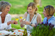 drei frauen trinken weißwein im garten