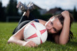 Cute girl lying on a football field