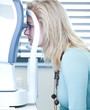 optometry concept - pretty young woman having her eyes examined