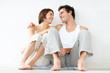 Cute young couple sitting together on the floor