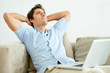 Handsome young man thinking while using laptop