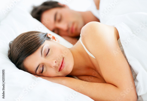 Photo: Beautiful young lady sleeping with husband on bed Beautiful young lady sleeping with husband on bed