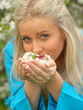 young woman is smelling white flowers